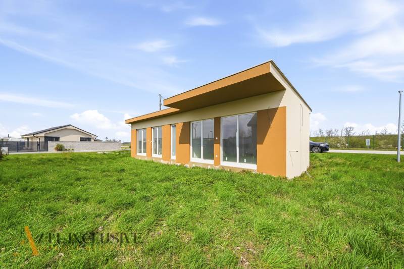 A cottage in Vojka nad Dunajom with a lawn and glass walls.