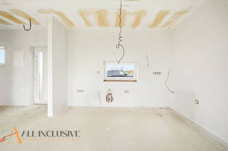 Interior of a cottage during renovation with bare walls and ceiling.