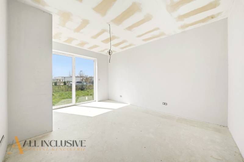 Spacious cottage with a large window and a view of the green surroundings.
