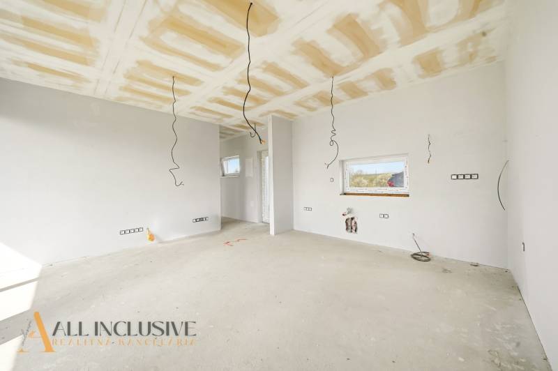 The interior of the cottage with preparations for electrical installations and white walls.