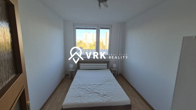 Bedroom with a double bed and wooden decor flooring in a two-room apartment.