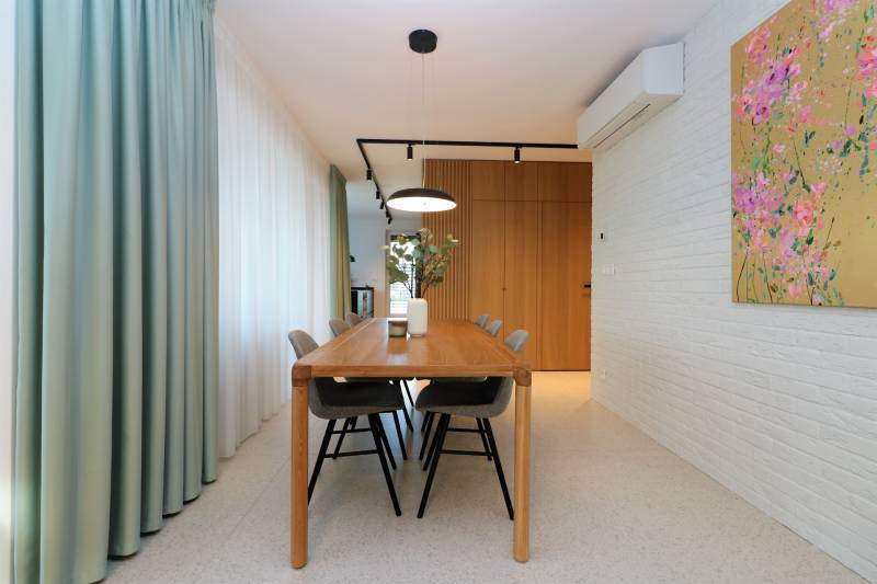 Dining room in a 4-room apartment with a wooden table and decorative painting on the wall.