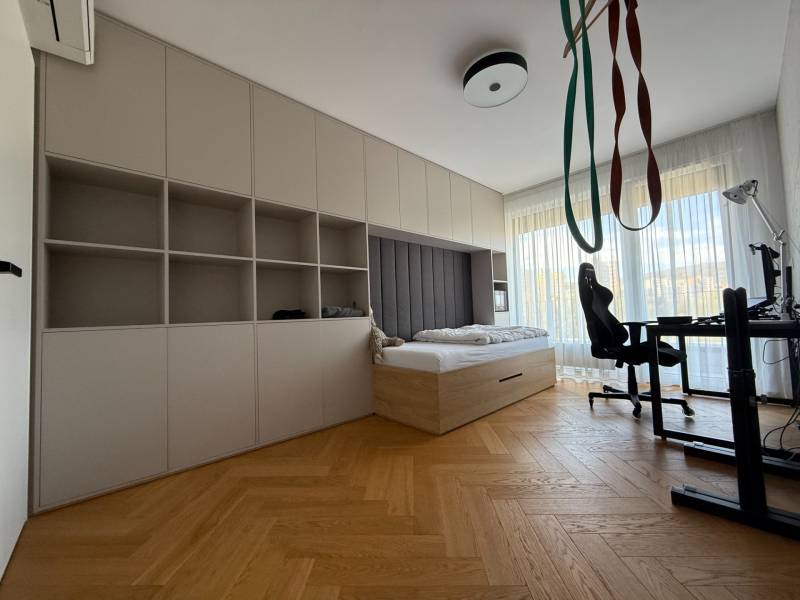 A room in a 4-room apartment with a bed, a table, and a floor with a wooden decor.