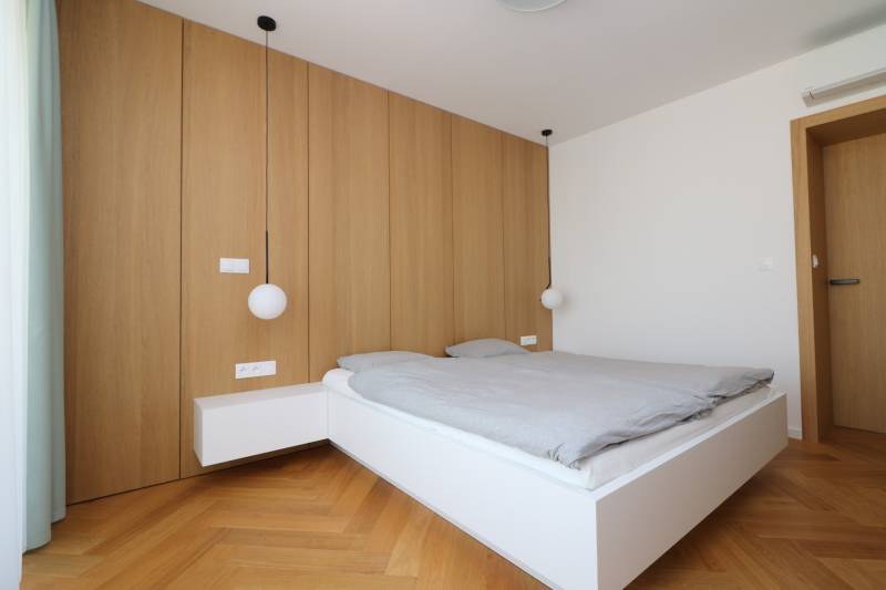 A bedroom with pendant lights and a wooden decor floor in a 4-room apartment.