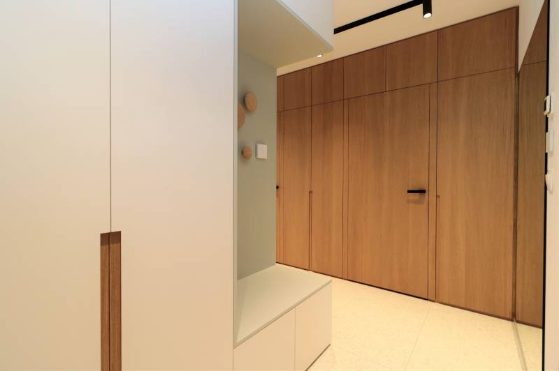 Interior of a 4-room apartment with a built-in wardrobe and flooring with a wood decor.