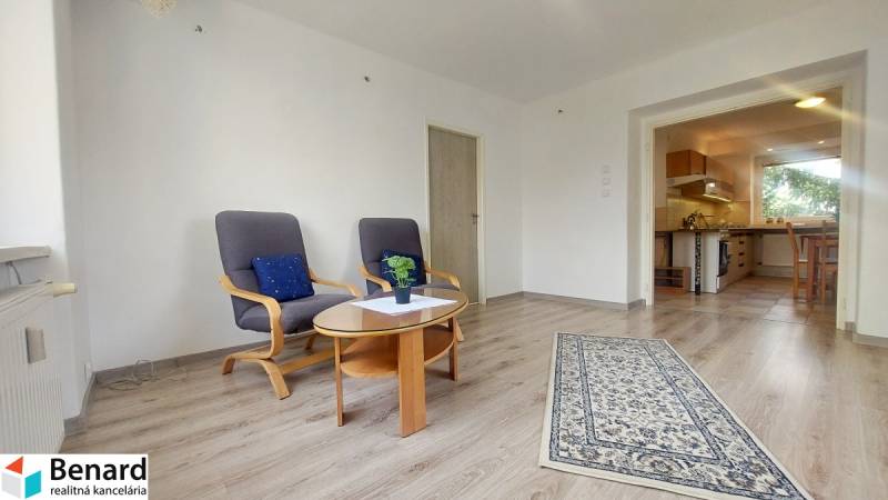 Living room in a two-room apartment with a wooden decor floor and comfortable armchairs.