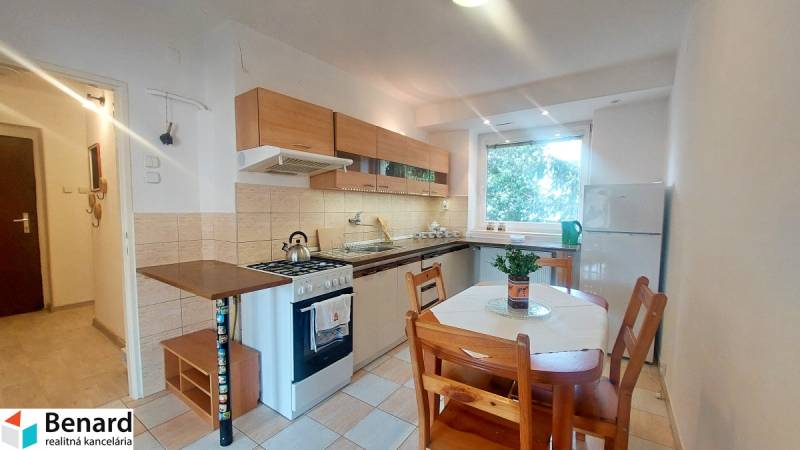 A kitchen with a kitchenette and a dining table in a 2-room apartment.