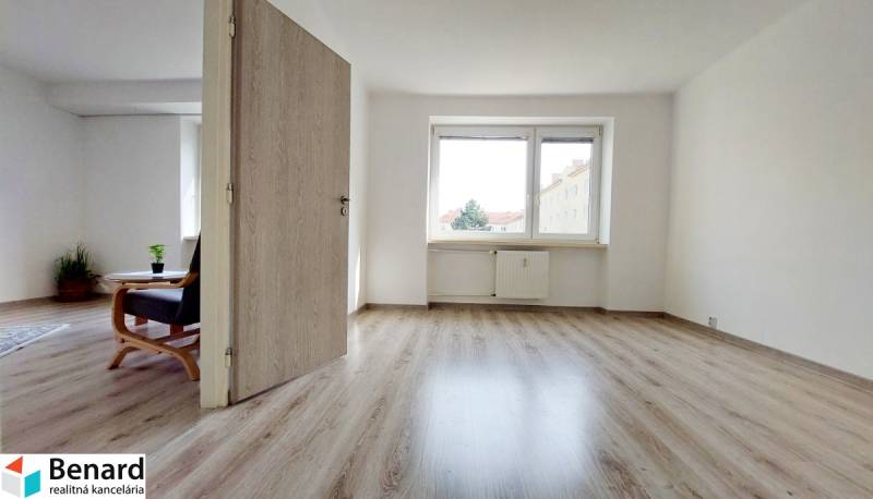 Interior of a 2-room apartment with a wooden decor floor and light walls.