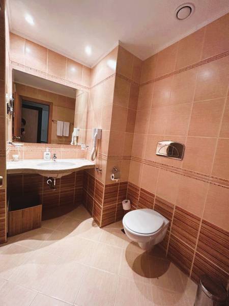 Bathroom in a studio apartment with tiled floor and beige walls.