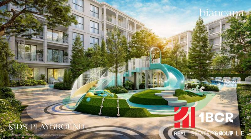 A children's playground at a residential development in Phuket with a large slide and greenery.