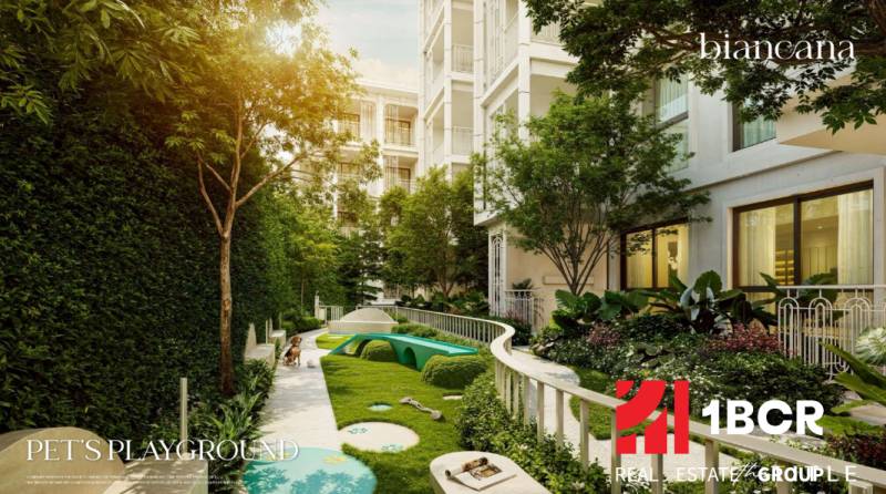 The exterior of a residential development in Phuket with a children's playground surrounded by greenery.