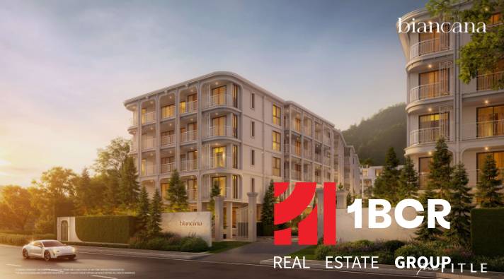Apartment construction in Phuket, an elegant building surrounded by greenery at dusk.