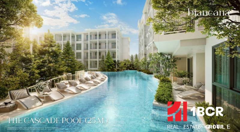 A pool with loungers surrounded by buildings under construction of apartments in Phuket.