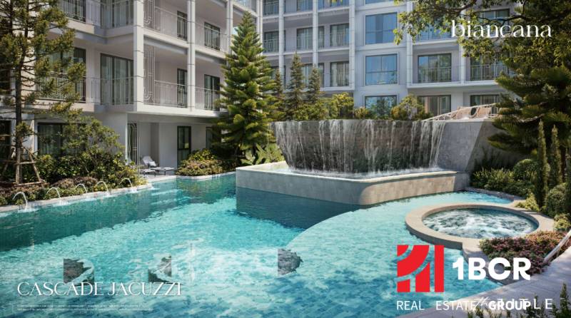 A swimming pool and jacuzzi surrounded by greenery during the construction of apartments in Phuket.