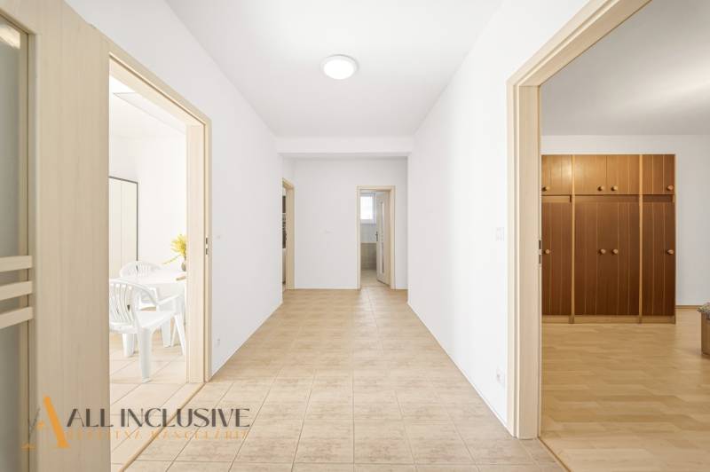A hallway in a family house with doors to the rooms and tiles on the floor.