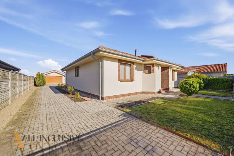 A family house in Kútniky with a paved walkway and a well-maintained garden.