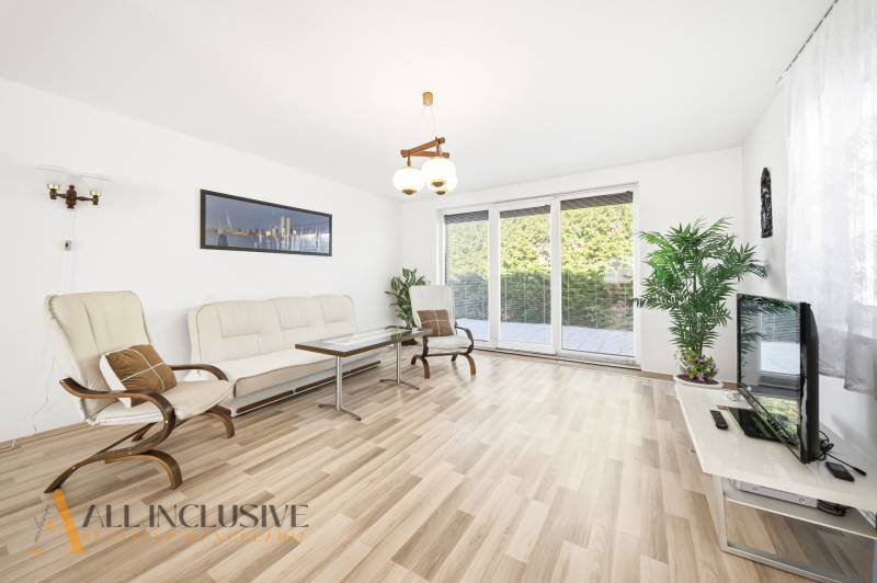 Living room in a family house with light furniture and a wooden decor floor.