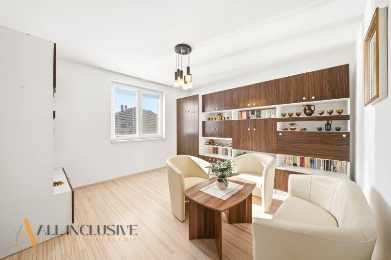 Living room in a family house with white armchairs and a wooden decor floor.