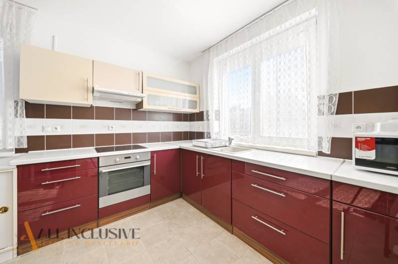 A kitchen in a family house with red cabinets and appliances.