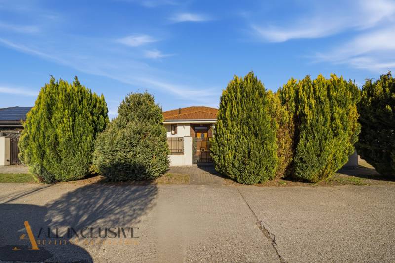 A family house in Kútniky surrounded by trimmed trees, beautiful front garden.