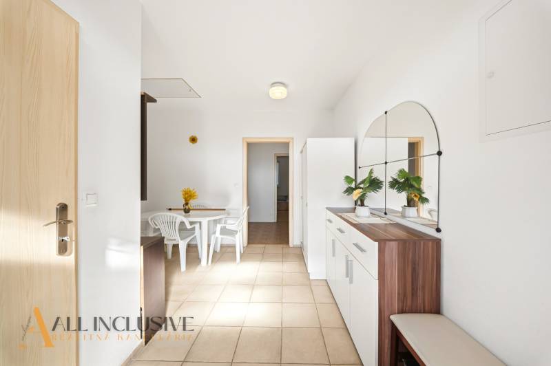 Interior of a family house with a white table and chairs, with a large mirror on the wall.