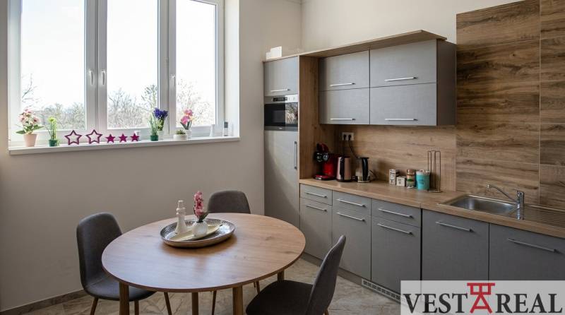 Kitchen corner in offices with a window, wooden decor, and a dining table.