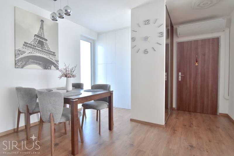 Dining area in a 3-room apartment with Eiffel Tower decor and wooden decor flooring.