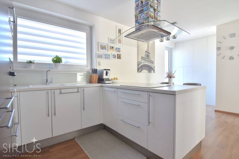 A kitchen in a 3-room apartment with Eiffel Tower decor and a wooden decor floor.