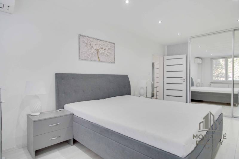 A bright bedroom with a large bed and a wardrobe in a 2-room apartment.