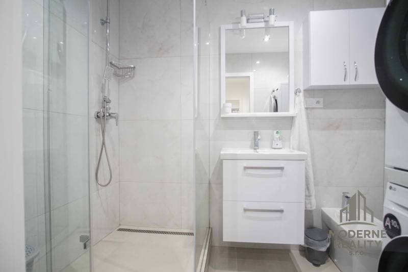 Bathroom in a 2-room apartment with a modern shower and a white sink.