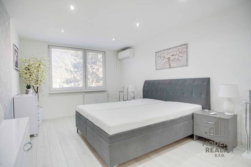 Bedroom in a 2-room apartment with a large bed and decoration in muted colors.