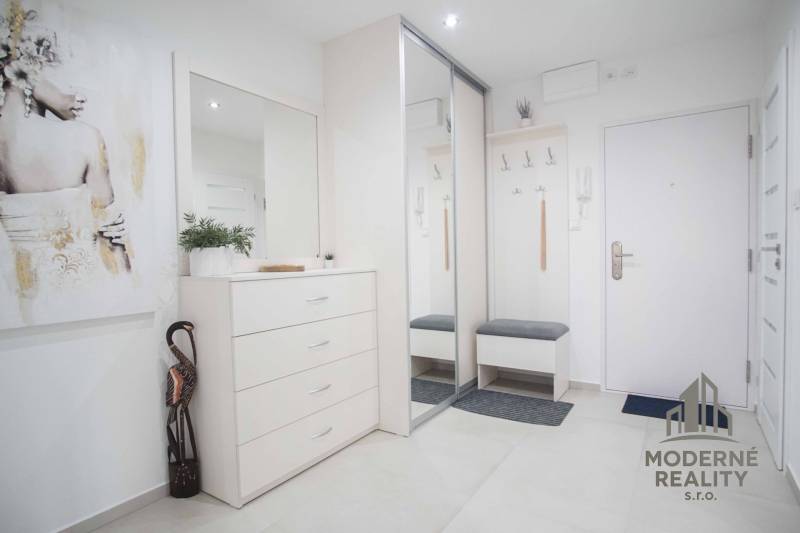 Entrance hall with white furniture and a mirror in a 2-room apartment.