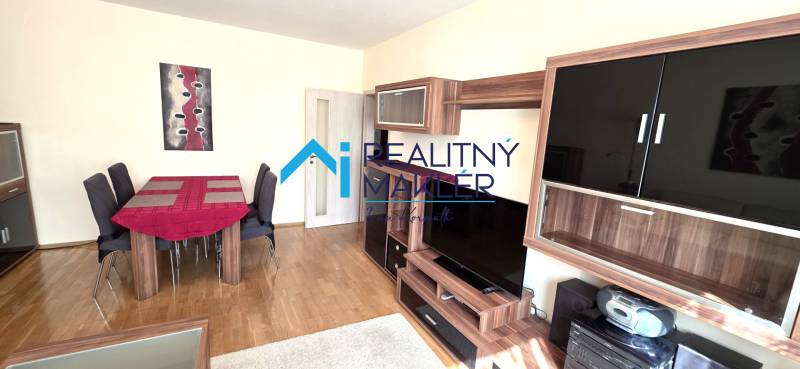 Living room in a 3-room apartment with furniture and flooring in a wood decor.