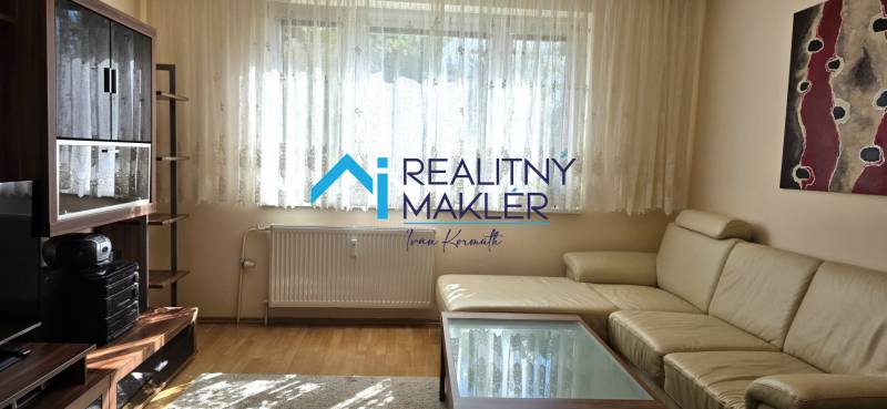 A living room in a 3-room apartment with a wooden decor floor and a leather sofa.