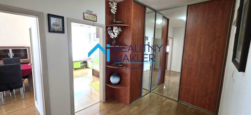 A hallway in a 3-room apartment with a wooden decor floor and a built-in wardrobe.