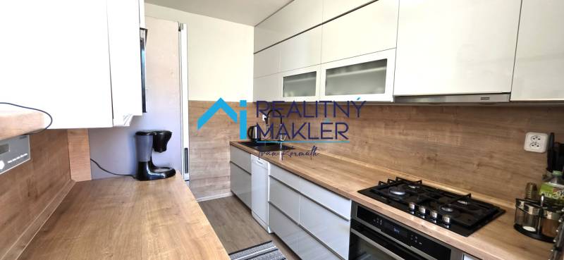 A kitchen in a 3-room apartment with a wooden decor countertop and floor.
