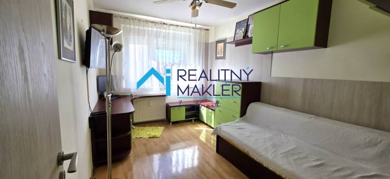 Living room with a sofa, shelves, and a table in a 3-room apartment, floor with wood decor.