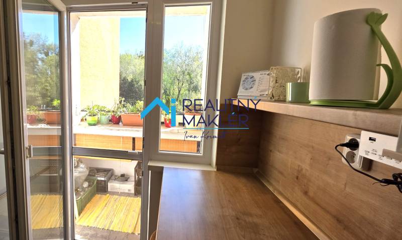 A bedroom with a desk and access to a balcony in a 3-room apartment.