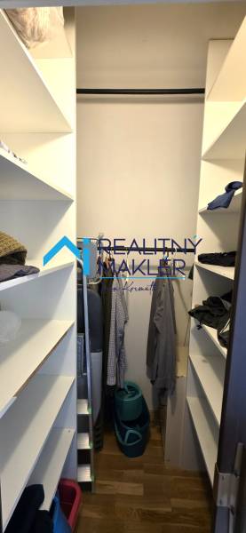A wardrobe with built-in shelves and a wooden decor floor in a 3-room apartment.
