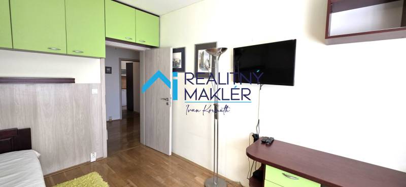 Interior of a 3-room apartment with wood-patterned flooring, green storage cabinets.
