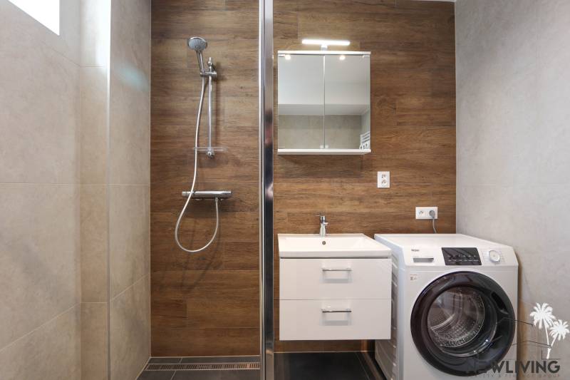 A bathroom in a 3-room apartment with wooden decor and a washing machine.