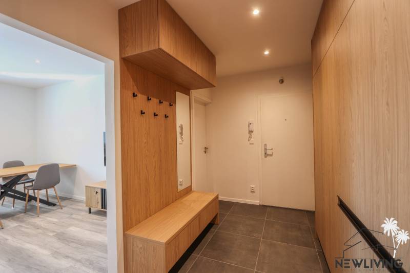 Entrance hall of a 3-room apartment with a tiled floor and wooden decor.