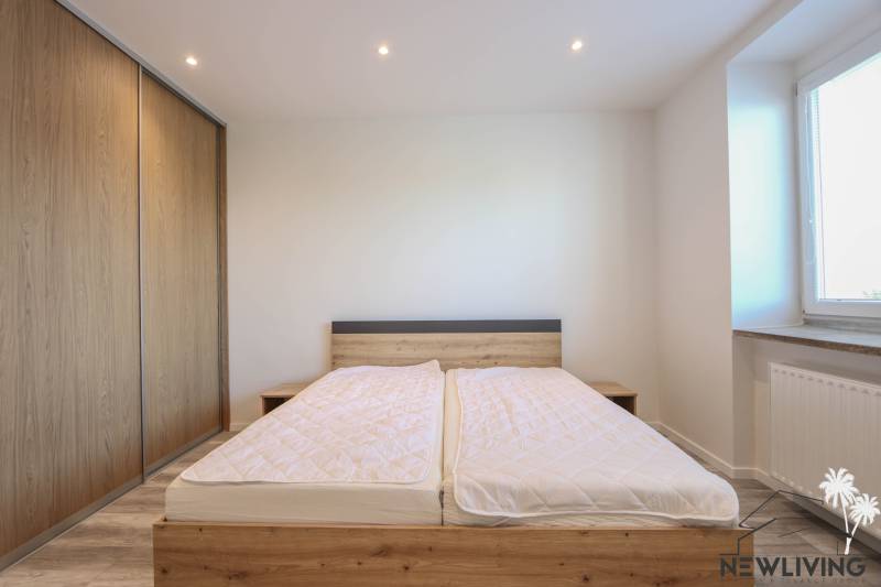 Bedroom in a 3-room apartment with a bed and a built-in wardrobe with a wooden decor.