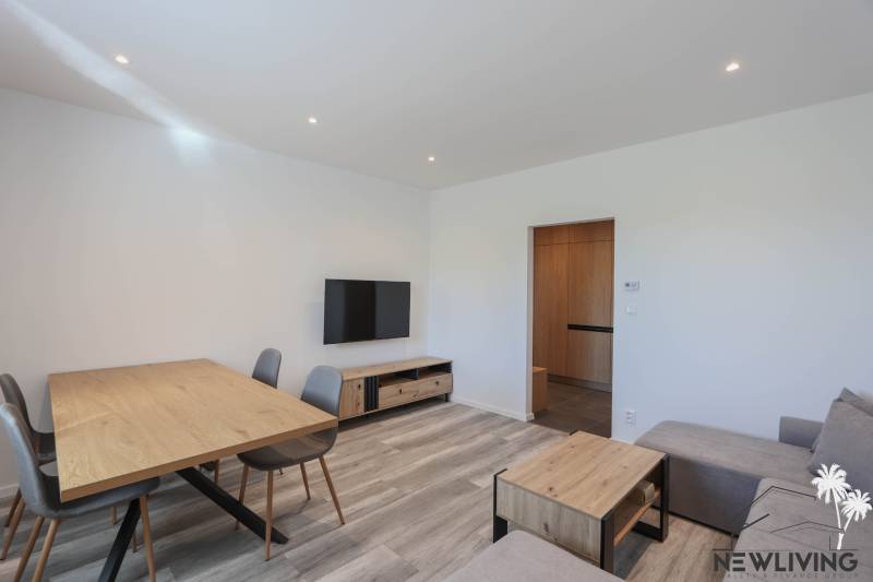 Living room in a three-room apartment with a wooden decor floor and wooden furniture.