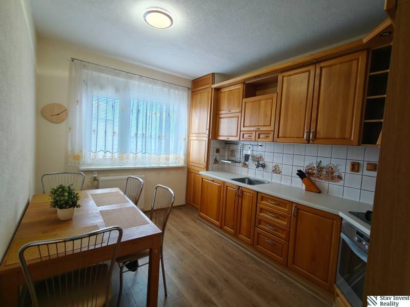 A kitchen in a 3-room apartment with a kitchen unit and a dining table.