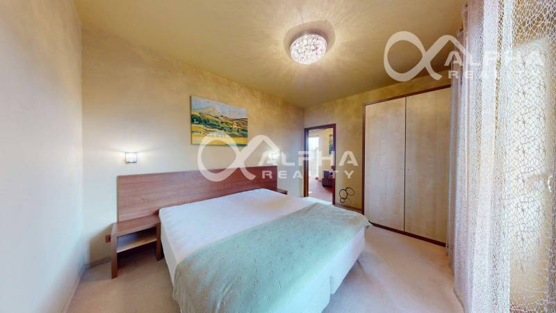 A bedroom in a 2-room apartment with a bed, a wardrobe, and a picture on the wall.