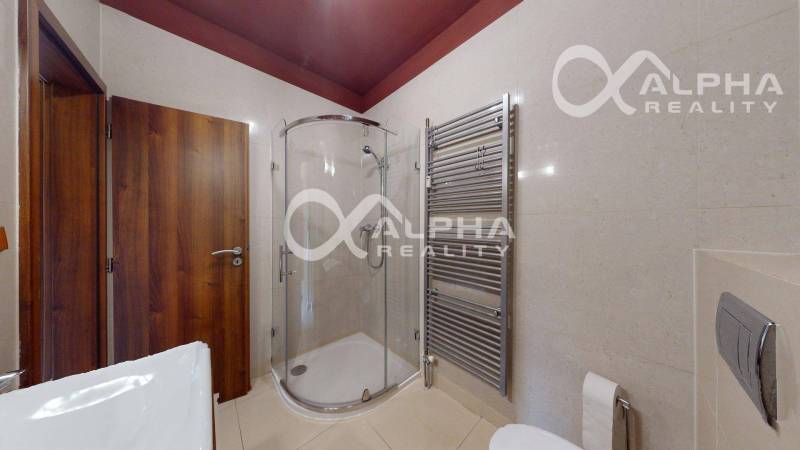 Bathroom in a 2-room apartment with a toilet, shower corner, and ladder radiator.