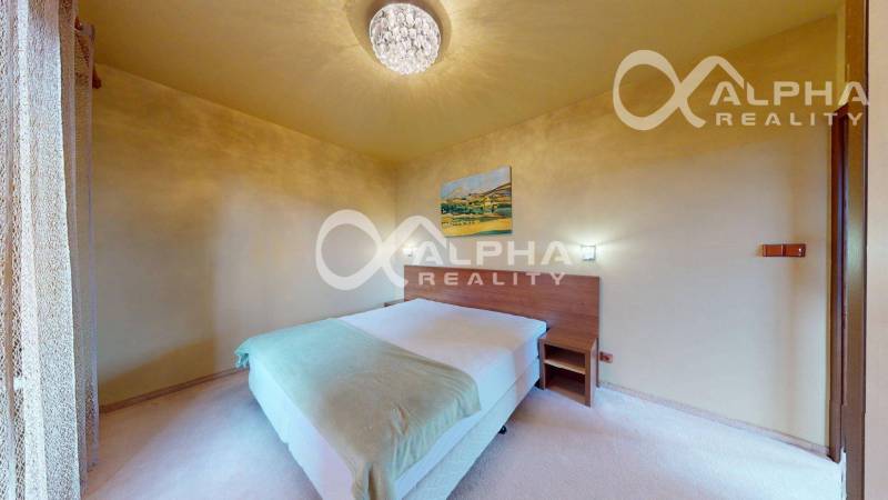 A bright bedroom in a 2-room apartment with a painting on the wall and a comfortable bed.