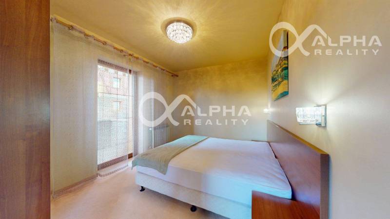 A bedroom in a two-room apartment with curtains and a chandelier, a bed, and nightstands.
