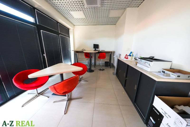 Offices with red chairs and a computer, tiled floor.